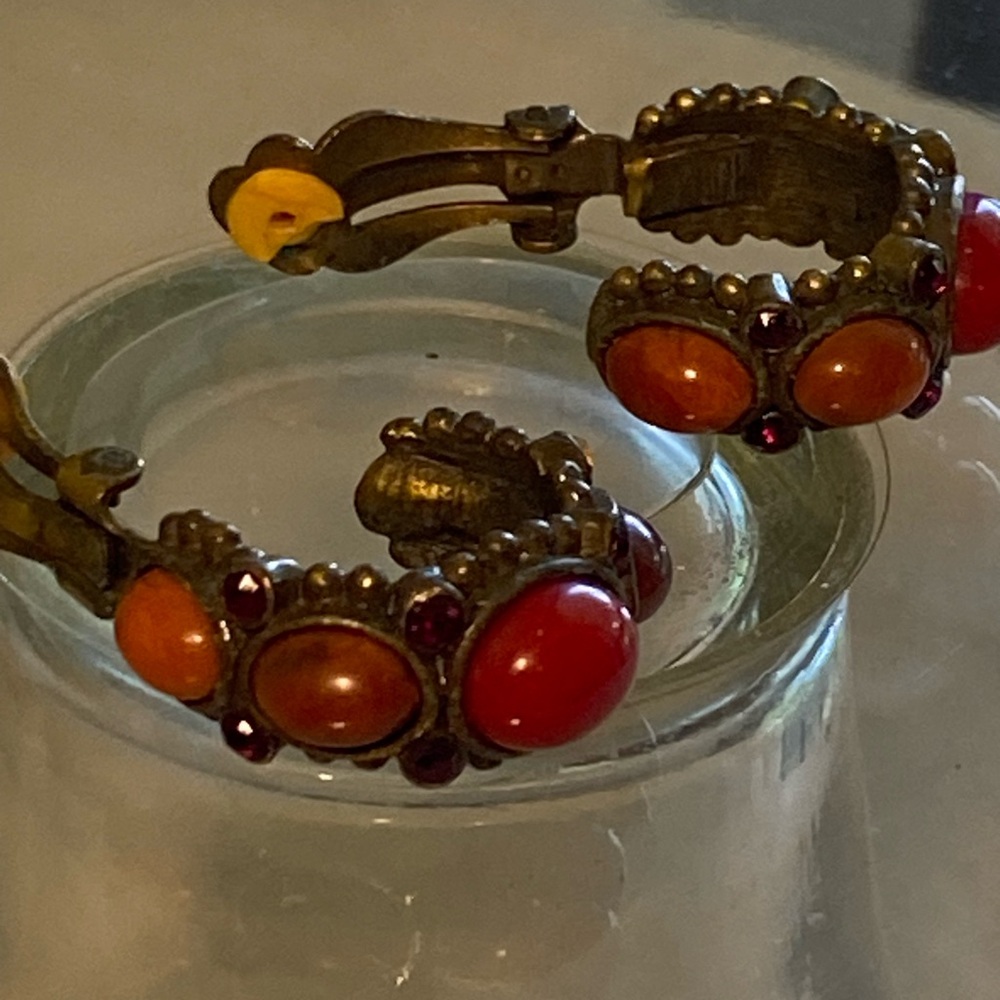 Vintage loop earrings with clip on red tone stones.